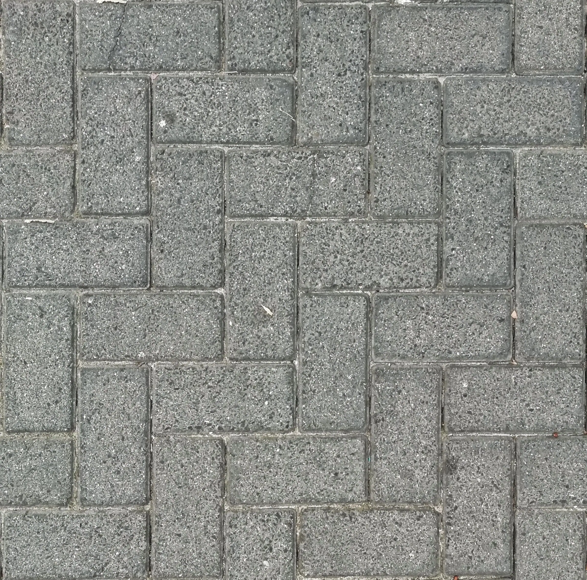 Gray pavers laid in a herringbone pattern, seen from above